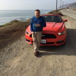 We hired a Ford Mustang to travel to style while stateside in California. Here, I pulled over to make a call with the North Pacific Ocean in the background.